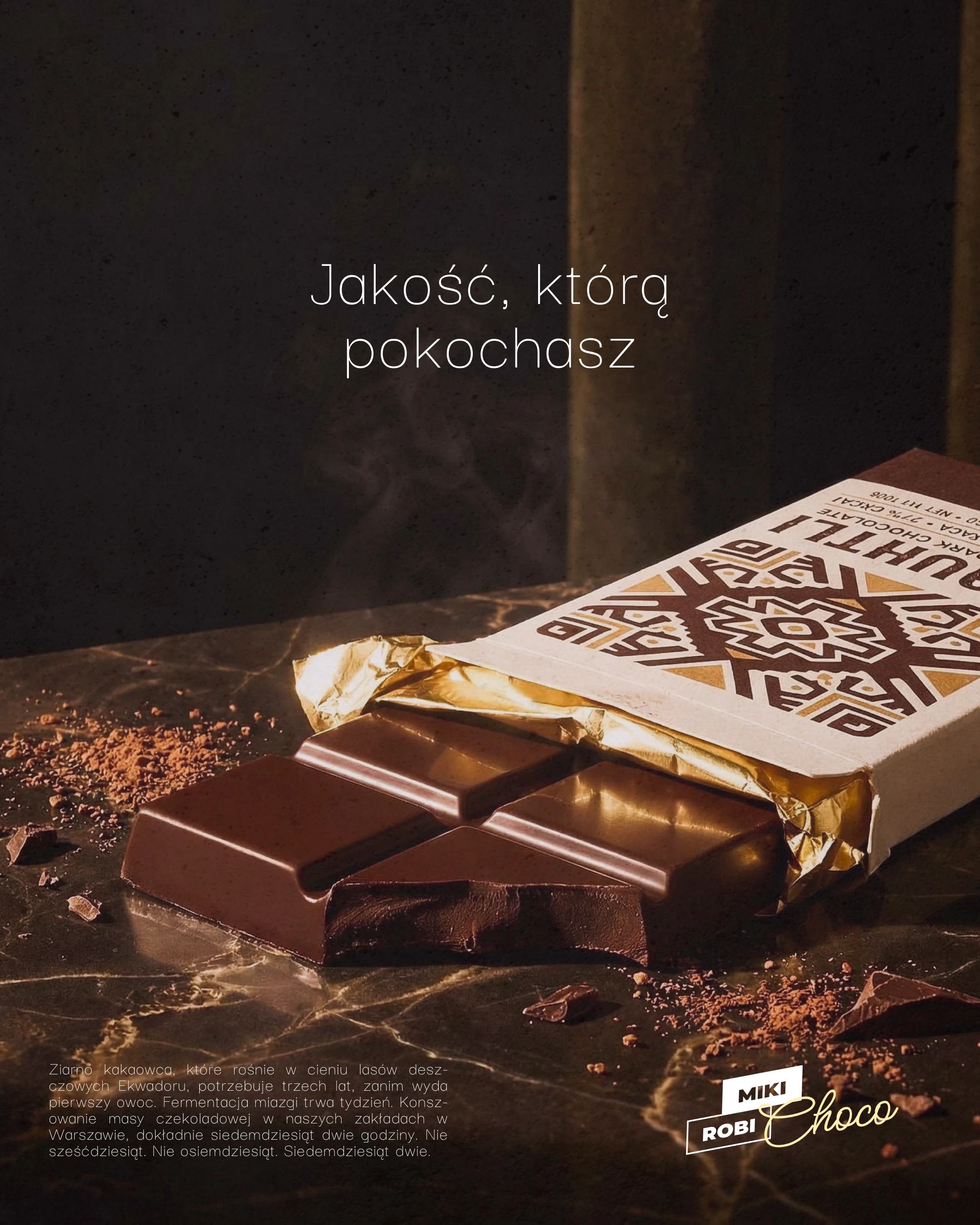 Rozłożona tabliczka czekolady Cuauhtli na ciemnym marmurowym blacie, złota folia, połamane kostki czekolady, rozsypane ziarna kakao